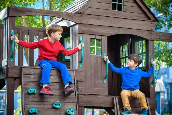 Zwei Kinder in einem Kletterhaus auf einem Spielplatz.
